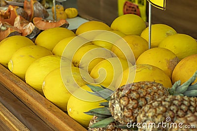 Yellow melon. Many melons to be sold and pineapple in the background Stock Photo