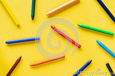 Yellow background with colorful wax pastel crayon pencils Stock Photo