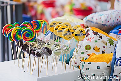 Yellow minion and rainbow lollypops, funny stick candy, school display for children Editorial Stock Photo