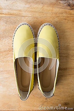 Yellow moccasin shoes on wooden table Stock Photo