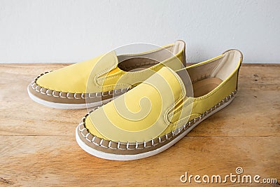 Yellow moccasin shoes on wooden table Stock Photo