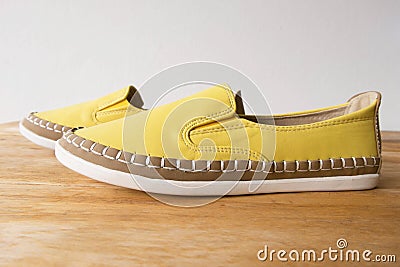 Yellow moccasin shoes on wooden table Stock Photo