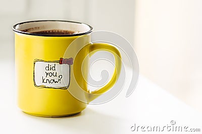 Yellow mug with coffee stands on a white window sill. with an inscription Stock Photo