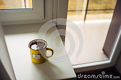 Yellow mug of coffee is on the window sill. The inscription on the circle. Did you know? Stock Photo