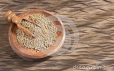 Yellow mustard seeds in the bowl and spoon Stock Photo