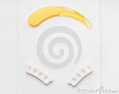 Nail file to remove the rough skin on the feet on a white towel and pedicure finger separator. Personal care at home Stock Photo