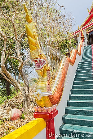 Yellow Naka (giant snake) statue on top of main stair leading to the replica of Phra That In-Kwaen (Hanging Golden Stock Photo