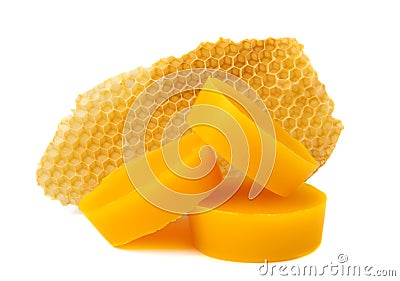 Yellow natural bee wax with a piece of honey cell on a white background. Stock Photo