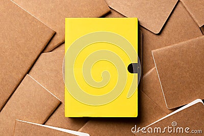 Yellow notebook on brown kraft notebook disorder alignment on table background.mockup template for display content or design. Stock Photo