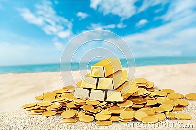 Gold bars and coins on sand beach Stock Photo