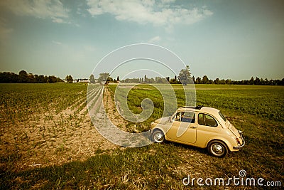 Yellow old car in a field, Italy Stock Photo