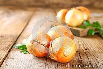 Yellow onion with parsley on a wooden table. Stock Photo