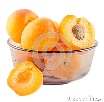 Yellow-orange apricots, half apricot with pip, in a brown transparent bowl Stock Photo