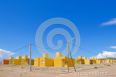 Yellow and orange colored row houses, terraced houses all built in the same style, Chilecito, La Rioja, Argentina Stock Photo