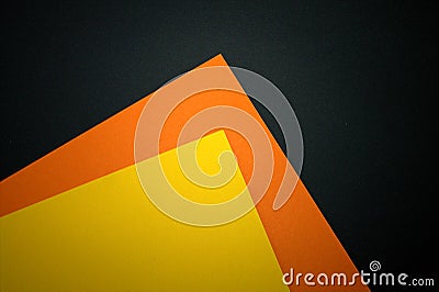 Yellow and orange paper on a black background. Stock Photo