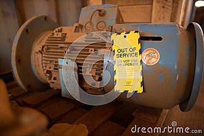 Yellow out of service tag attached on faulty damage defect of electric power motor Stock Photo
