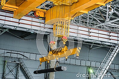 Yellow overhead crane carries cargo in engineering plant shop Stock Photo