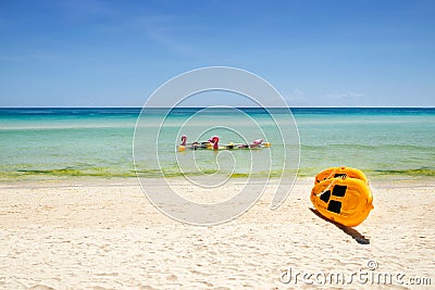 Yellow paddle boards and children boats on tropical beach Stock Photo