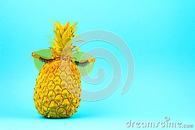 Yellow painted pineapple in sunglasses with artificial lashes. Humour, summer patry, fun concept Stock Photo