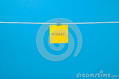 Yellow paper sheet on the string with text Monday Stock Photo