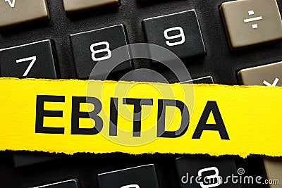 Yellow paper strip on a notepad. EBITDA Earnings before Interest, Taxes, Depreciation and Amortization. Stock Photo