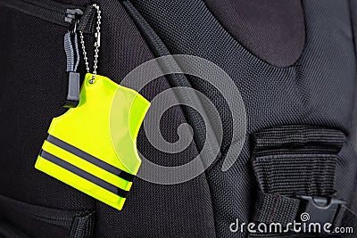 Yellow pedestrain safety reflector on a black backpack, closeup Stock Photo