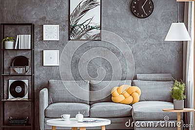 Yellow pillow on grey settee Stock Photo