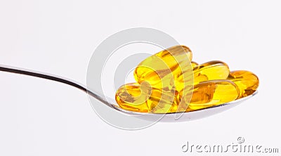 Yellow pills on spoon Stock Photo