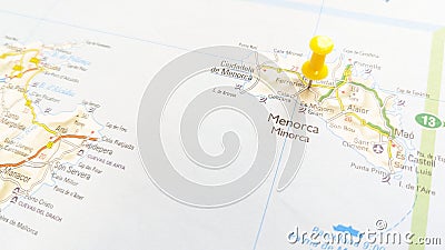A yellow pin stuck in the island of Menorca on a map of Spain Stock Photo