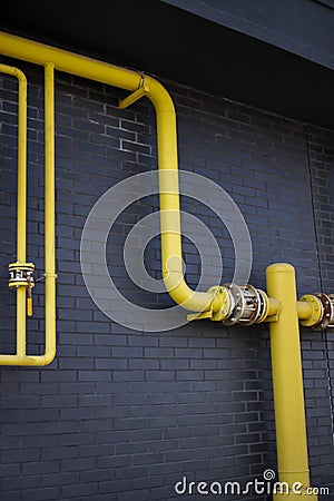 Yellow pipes, black wall Stock Photo