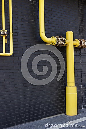 Yellow pipes, black wall Stock Photo