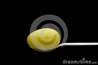 Yellow plastic Easter Egg on a white spoon Stock Photo