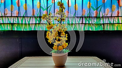 Yellow plastic flowers are placed on the table to decorate the room Stock Photo