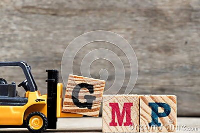 Yellow plastic forklift hold letter G to complete GMP Stock Photo