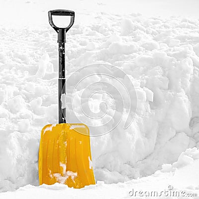 Yellow plastic shovel stuck in fluffy white snow in winter Stock Photo