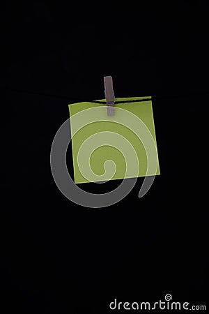 Yellow post it with wooden clothespin with dark background copy space vertical annotation Stock Photo