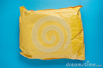 Yellow postal cardboard package on blue background Stock Photo