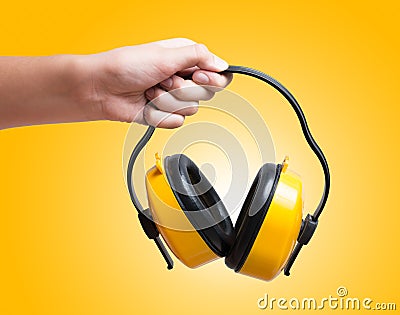 Yellow protective ear muffs in hand Stock Photo
