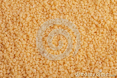 Yellow raw couscous grain background. Close up Stock Photo