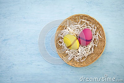 Yellow and red Easter egg in round rattan basket Stock Photo