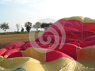 A yellow-red-green balloon during air filling Stock Photo
