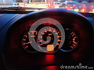 Yellow Red Illuminated Speedometer Console Against Blurred Traffic Background Stock Photo