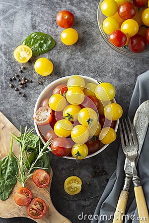 Yellow and red tomatoes in plate, isolated over dark background Stock Photo