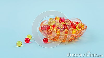 Yellow and red vitamin A, E, D, omega 3, cod-liver, fish, Evening primrose oil dietary supplement gel capsules in glass plate on Stock Photo