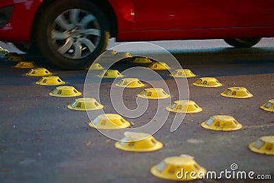Yellow reflective road studs on a city street, used as a traffic calming measure. Stock Photo