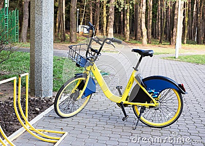 Yellow rental bike stands near the bike parking Stock Photo