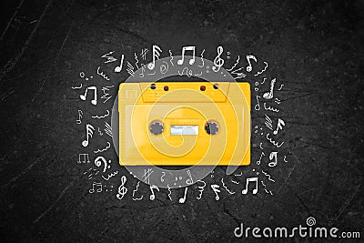 Yellow retro Cassette tape over blackboard. top view. music sketches Stock Photo