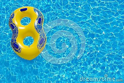 Yellow rubber ring floating on blue water Stock Photo