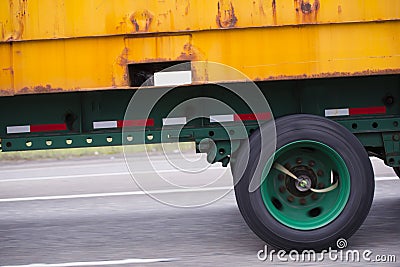 Yellow rusty container on flat bed semi trailer driving on the r Stock Photo