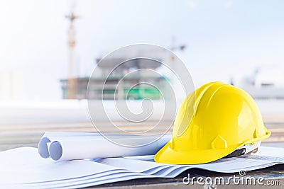 The yellow safety helmet and the blueprint at construction site Stock Photo